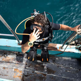 Duiker van Below Zero Divers stapt vanaf de boot het water in