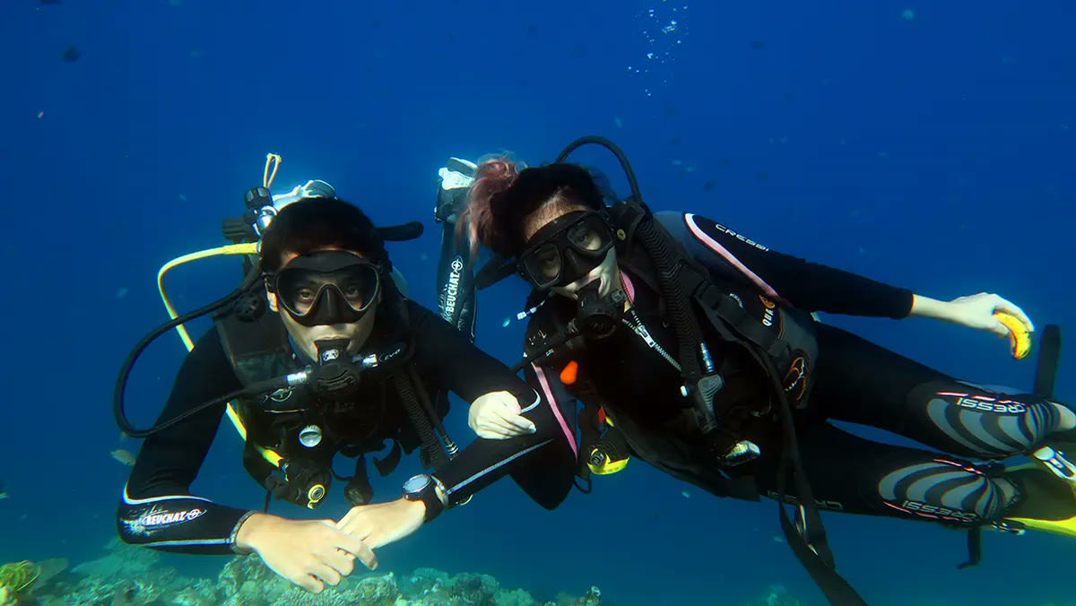 Twee duikers van Palawan Divers onder water in El Nido