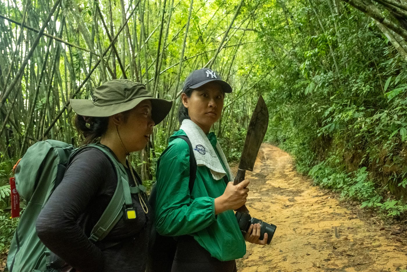 Junglegids met kapmes tussen de bamboe onderweg naar het kamp