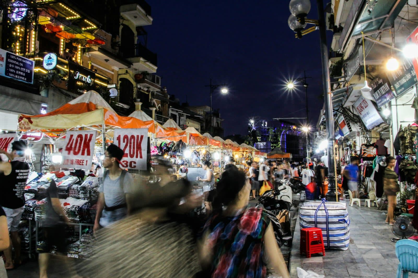 Drukke nachtmarkt met verlichte kraampjes en winkels