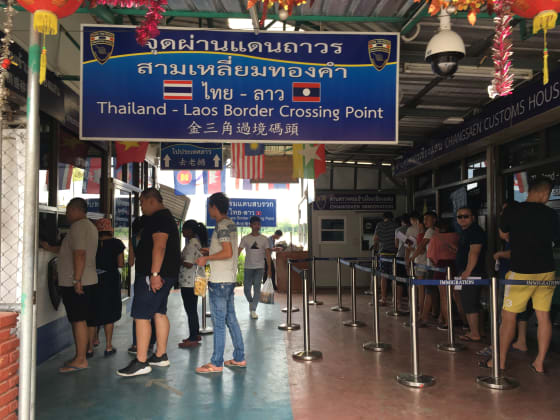 Reizigers in de rij bij de grenspost tussen Thailand en Laos