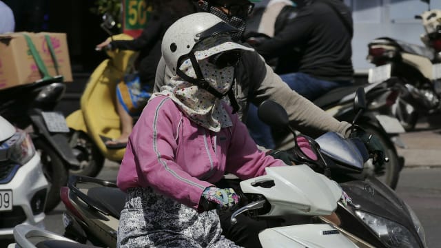 Scooterrijder met witte helm in het verkeer