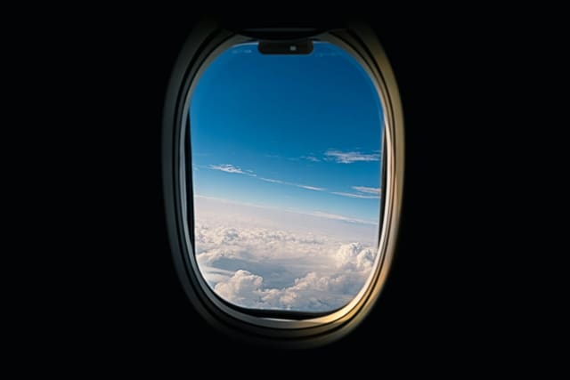 Uitzicht op wolken vanuit een vliegtuigraam