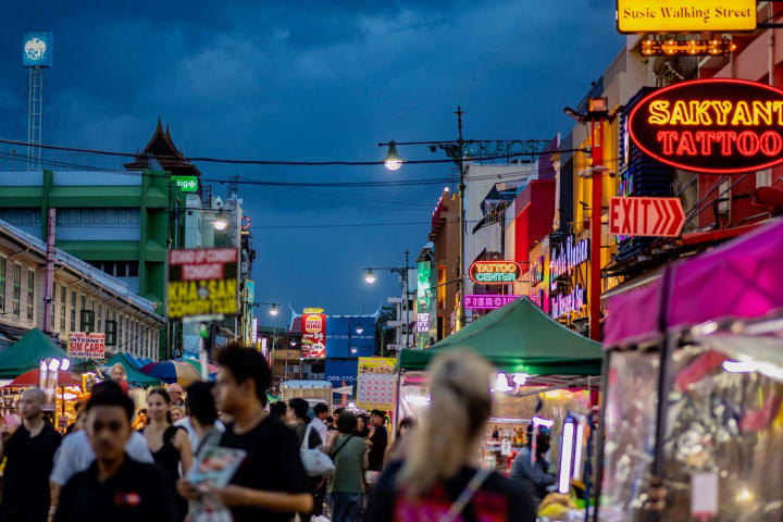Khao San Road in Bangkok in de avond, vol neonreclame en reizigers