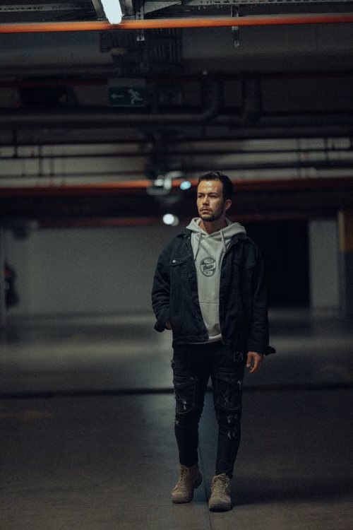 Black and white shot of a baggy jacket worn in a dim underground corridor