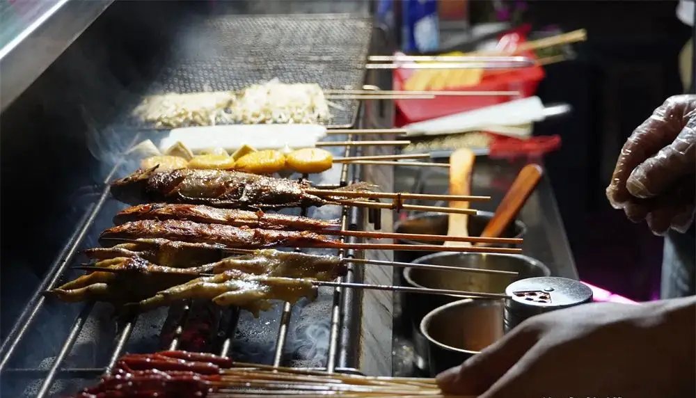 Charcoal grill smoke rising at a street barbecue stall in Changsha