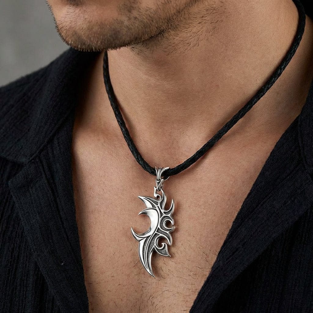 Black and white silver flame pendant necklace resting on dark fabric