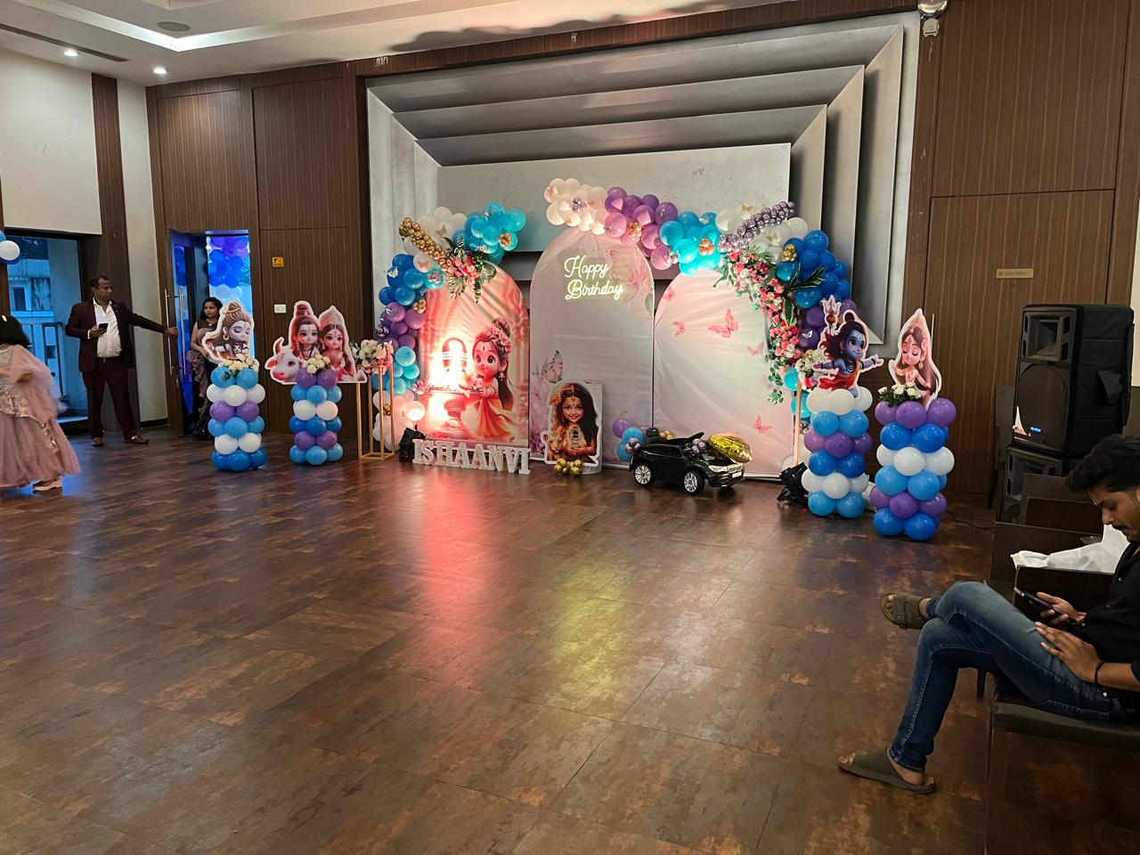 The themed first-birthday stage inside the event hall at Shrushti Complex in Mira Road East