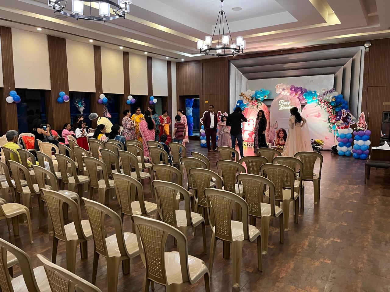 Guest seating arranged in front of the first-birthday stage at the Mira Road East venue