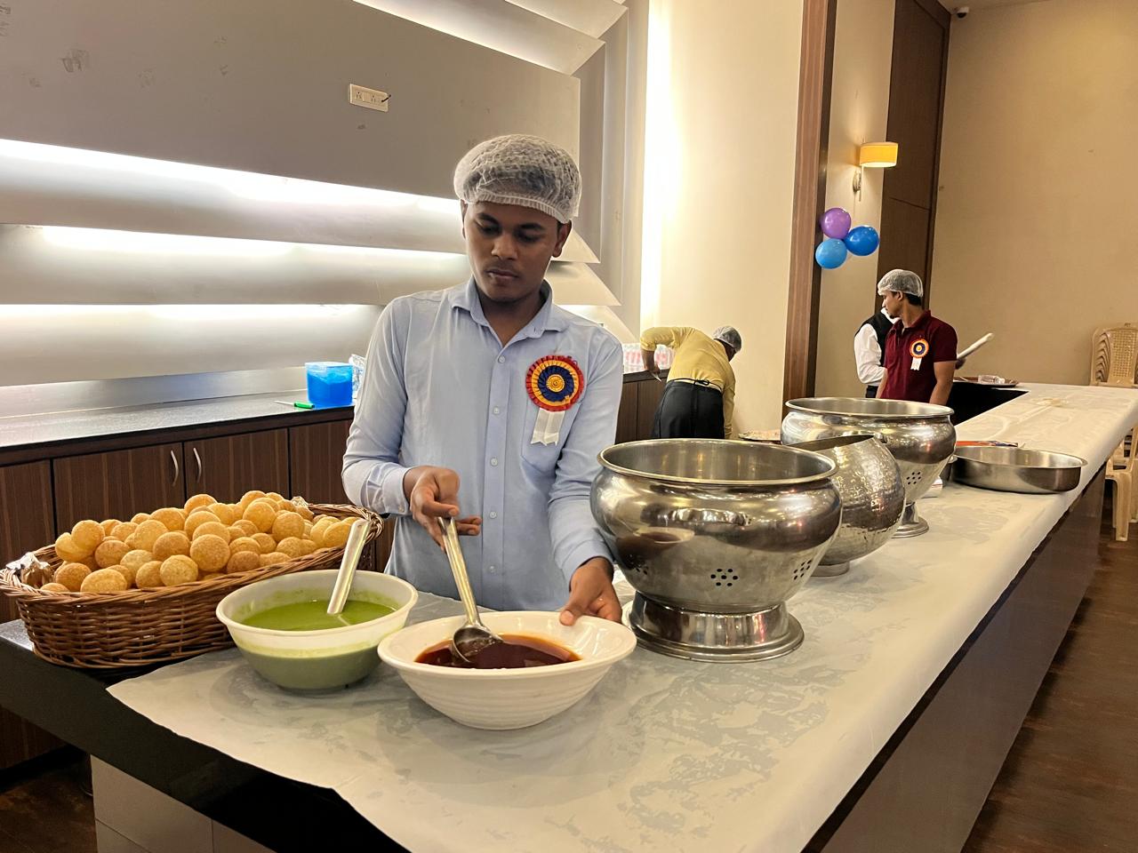 Pani puri counter prepared with puris, chutneys, and serving vessels