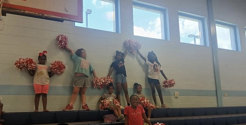 Girls cheering during Hoop2Heal programming