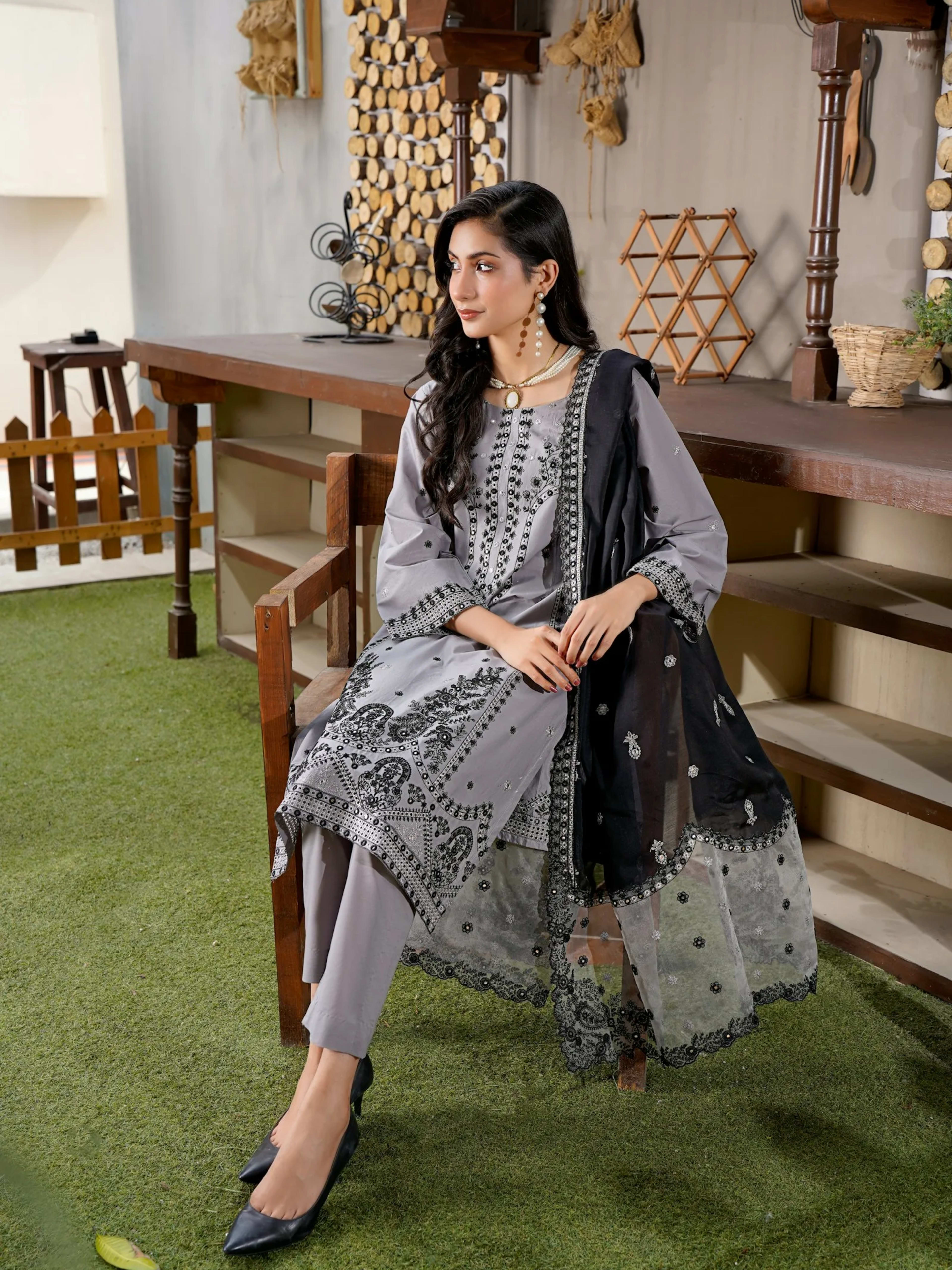 Dua: A woman in a grey traditional outfit with black scarf (stand-in photo: Muneeb Malhotra on Unsplash)