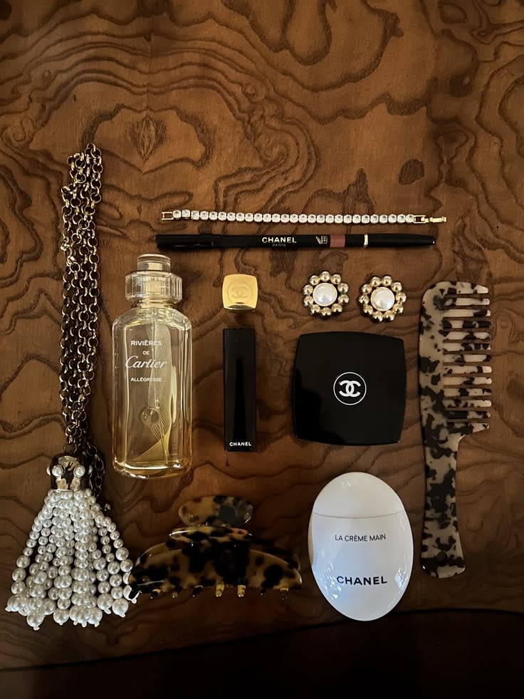 Mise en scène d'une collection d'objets de design et montres de luxe sur une étagère en bois précieux.