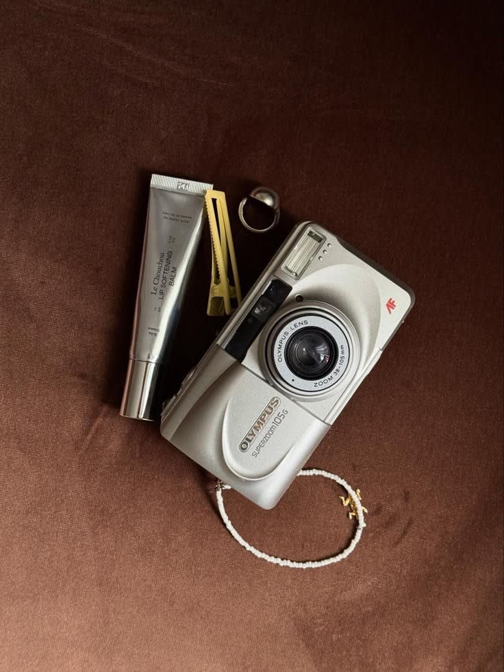 Rolleiflex 2.8F posé sur une table en bois, numéro de série visible sur la semelle, bouchon d'objectif d'origine à côté