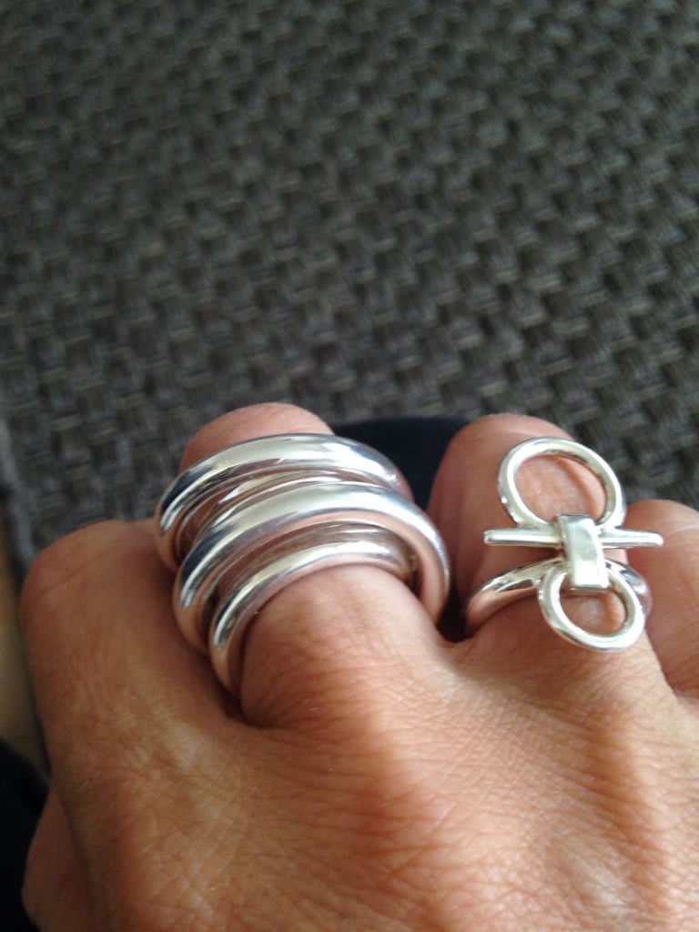 Bague en or 18 carats avec poinçon tête d'aigle visible et pierre saphir, posée sur une surface en marbre blanc