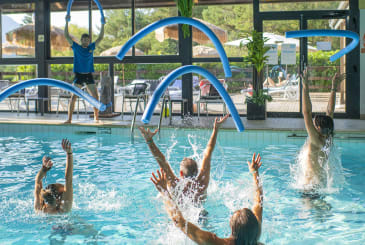 Cours d'aquagym dans une piscine intérieure, les participants lançant les frites en l'air - Club*** Les Horizons du lac - Chorges