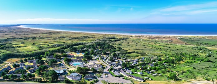 Complexe hôtelier entouré de nature avec 'océan en fond sous un ciel bleu - Club Keravel*** - Erdeven