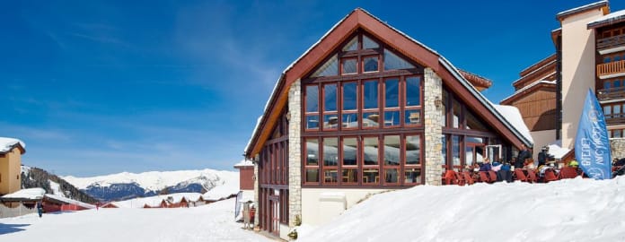 Hôtel sous un ciel bleu avec pistes enneigées devant et montagnes en arrière plan - Hôtel*** L'eden des cimes - La Plagne