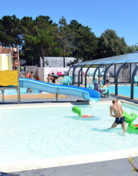Enfants jouant dans une piscine extérieure avec toboggans - Club*** Keravel - Erdeven