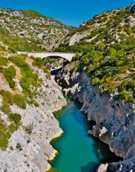 Le pont du diable en pierre surplombant les gorges et la rivière sous un ciel bleu - Résidence*** Lou Castel - Ardèche