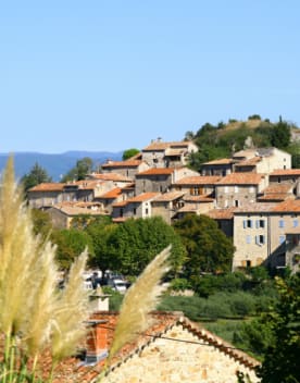 Vue du village de bannes sous un ciel bleu et en arrière plan les montagnes - Résidence 3* Lou Castel - Ardèche