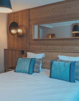 Chambre lit double avec oreillers et miroir - Eden des Cimes - Vacances Bleues