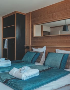 Chambre lit double oreilles serviettes de toilette et miroir - Eden des Cimes - Vacances Bleues