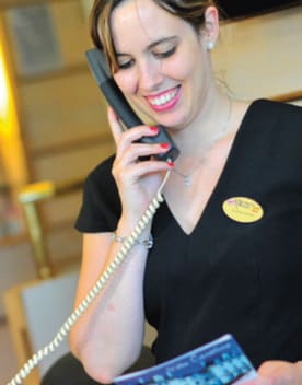 Une femme à l'accueil de l'hotel, au téléphone