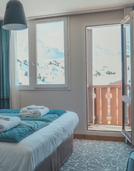 Chambre lit double avec oreillers et peignoirs ouvrant sur un balcon - Eden des Cimes - Vacances Bleues