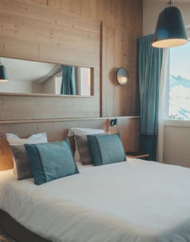 Chambre lit double oreillers et miroir - Eden des Cimes - Vacances Bleues