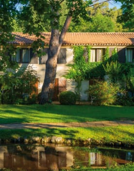 Vue des logements locatifs du domaine avec un petit étang devant - Club*** Château Laval - Gréoux les Bains