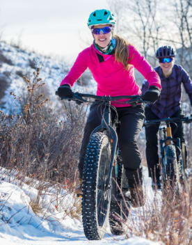 deux femmes sur des vélos à grosses roues en montagne dans la neige - Hôtel*** L'Eden des cimes - La Plagne