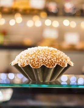 Brioche recouverte de grains de sucre dans un moule en acier présentée en vitrine - Vacances Bleues