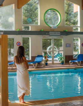 femme devant piscine intérieure - Un séjour bien-être à la neige