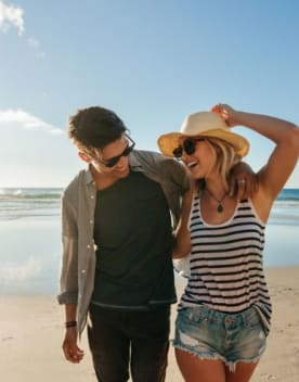 Couple sur la plage se tenant par la taille - Vacances Bleues