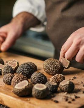 Chef préparant des truffes sur un plateau de bois - Résidence 3* Lou castel - Ardèche