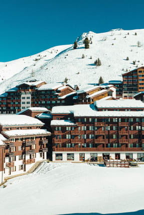 Vue aérienne de l'hôtel et de la station en arrière plan les montagnes enneigées - Hôtel*** L'Eden des cimes - La Plagne