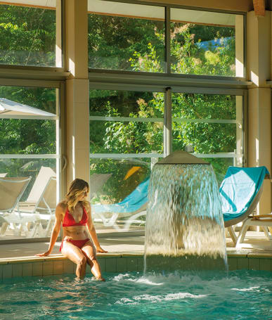 The indoor pool with waterfall at the Domaine de Château Laval