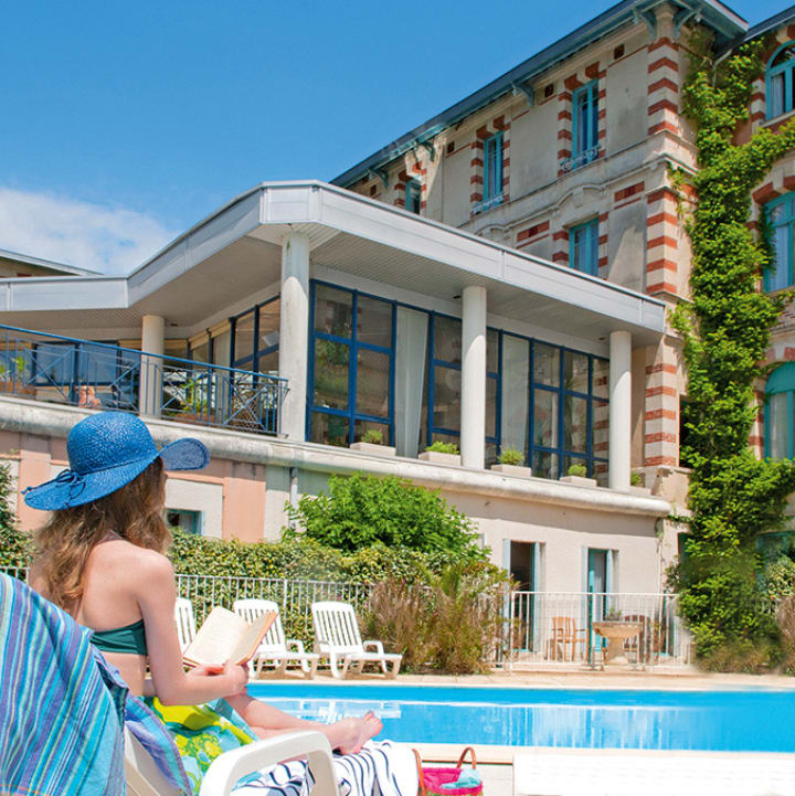 Femme sur un transat au bord de la piscine de la Villa Régina - Vacances Bleues- Arcachon