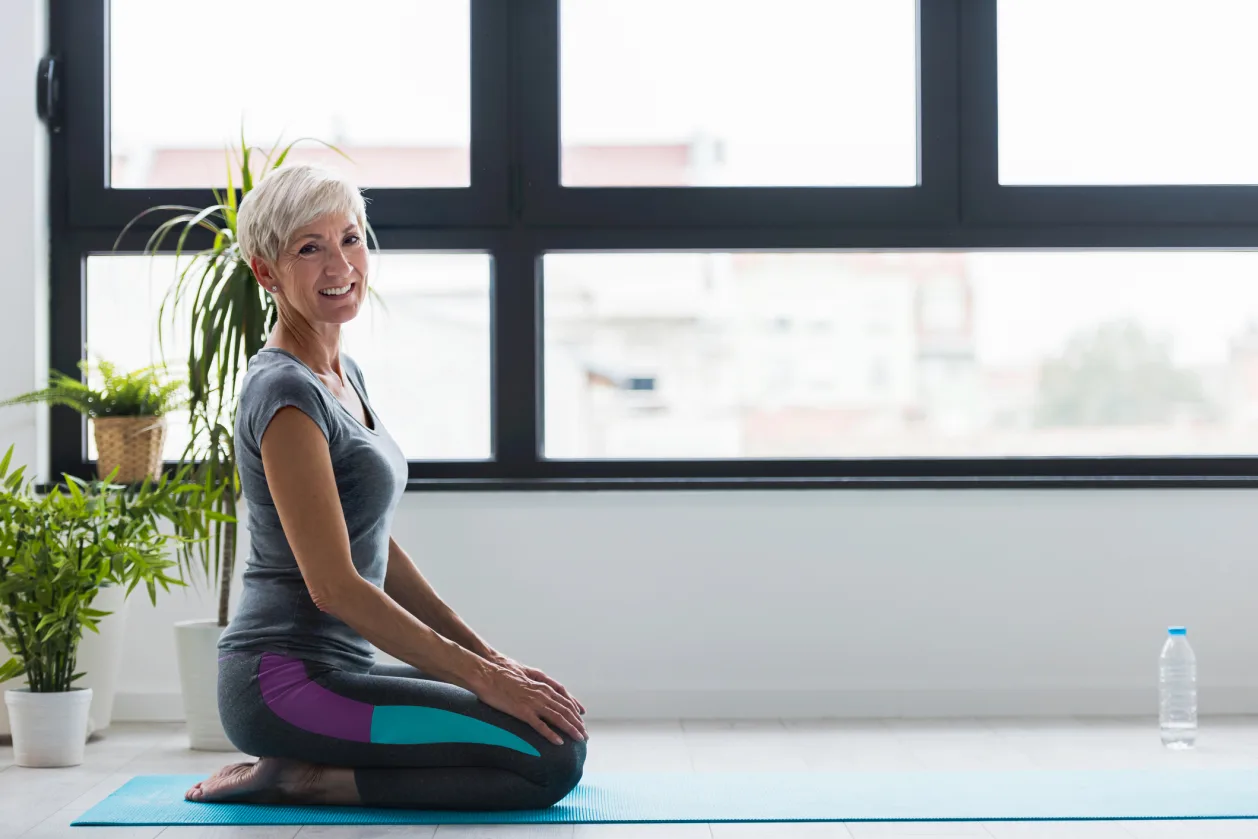 mature woman practicing yoga as physical rest one of 7 types of rest
