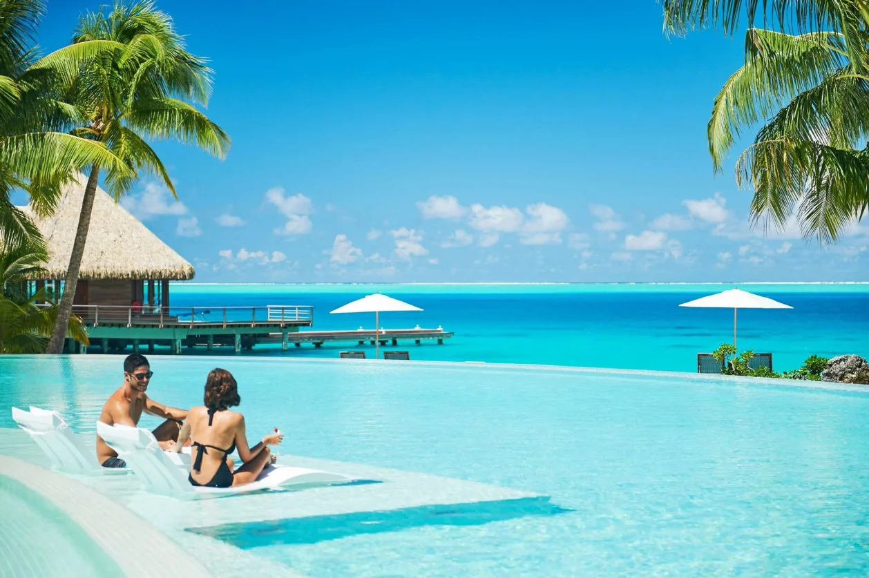 Couple in pool at Conrad Bora Bora Nui unique honeymoon destination
