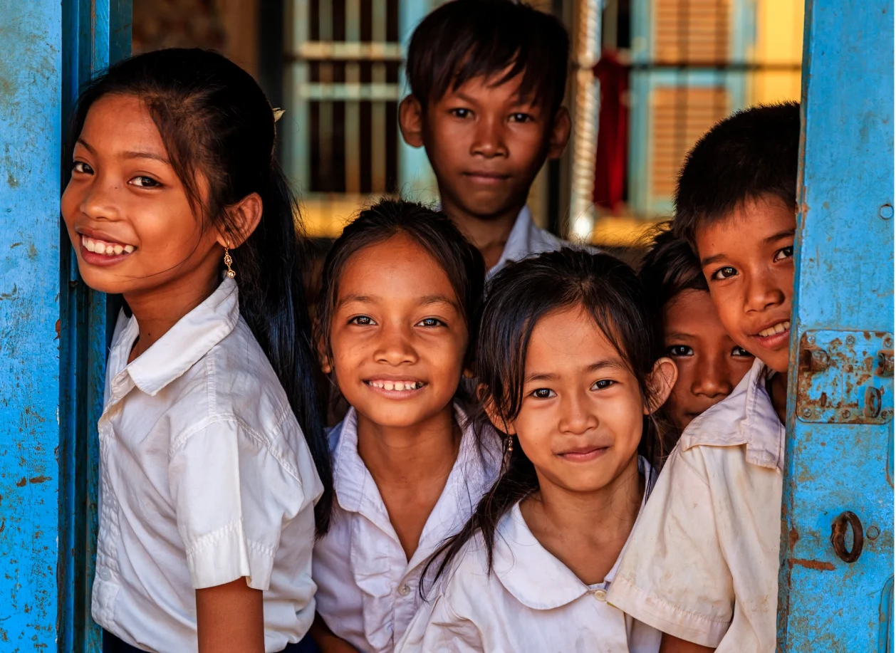 Cambodian school children standing in door frame of classroom