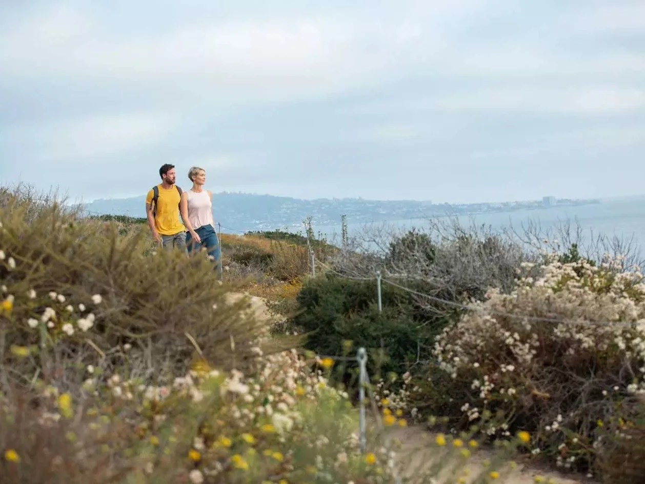 L'Auberge Del Mar couple hiking coastline