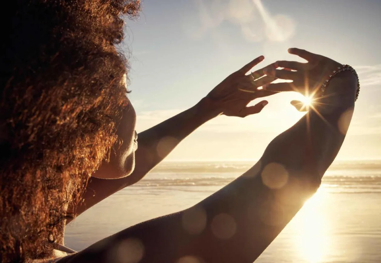 Rearview shot of a young woman blocking the sunlight with her hands at the beach