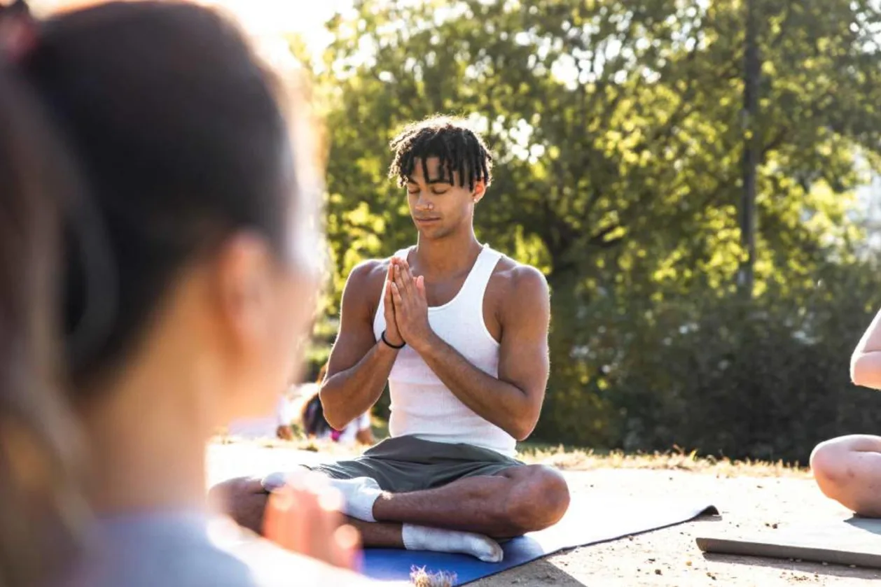 Male Gen Z doing yoga in open-air park