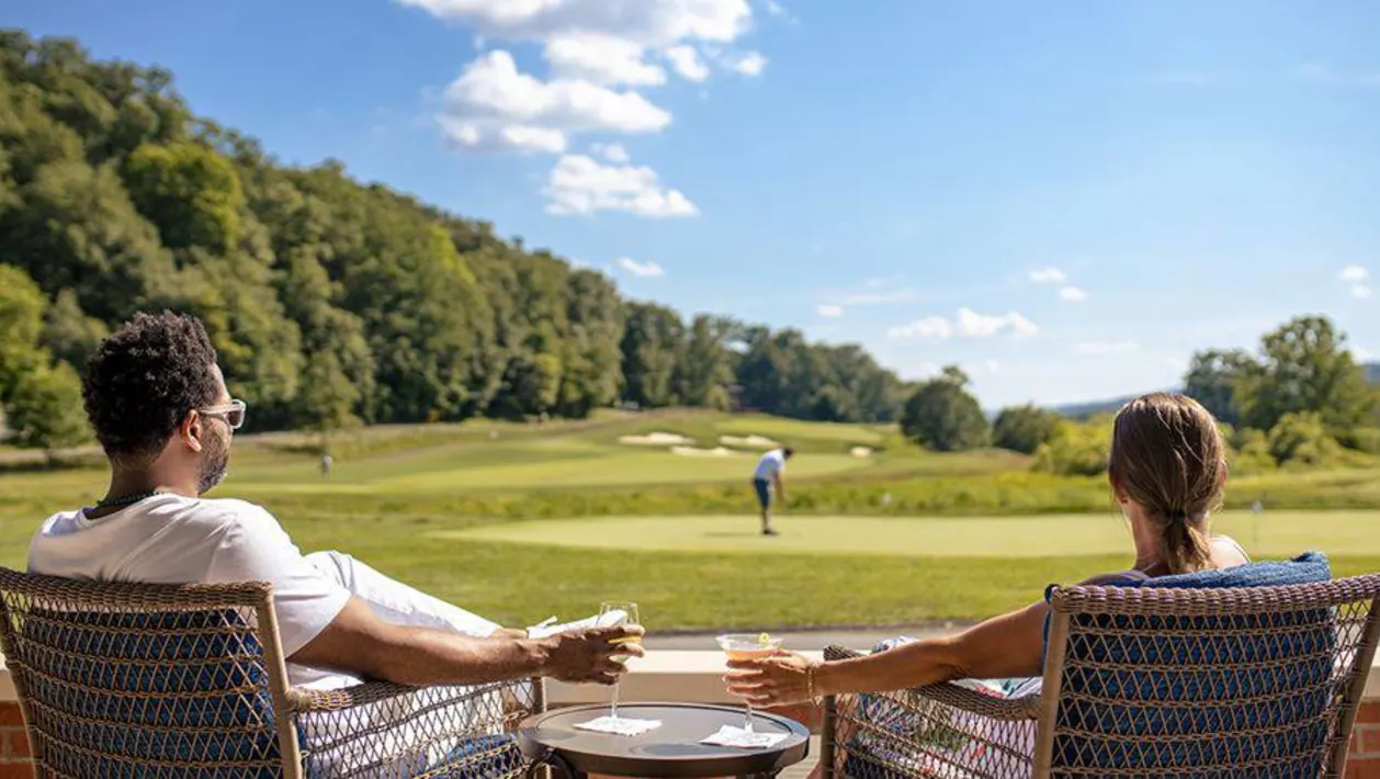 Couple relaxing near golf course at Omni Bedford Springs