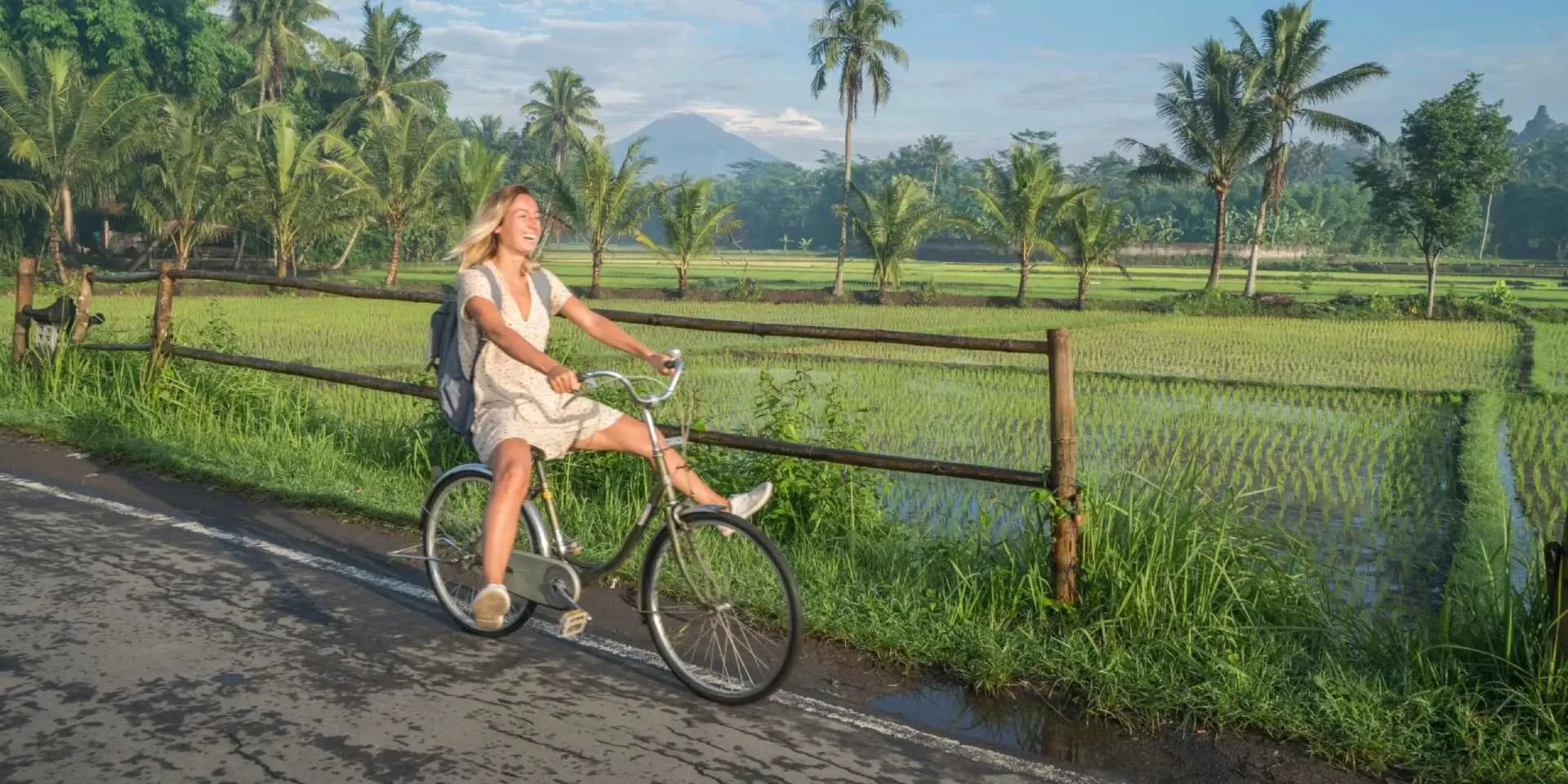 Woman riding bike through rice fields Bali
