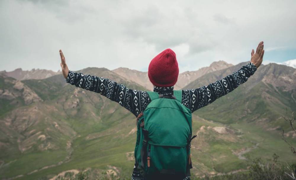 Female hiker open arms on mountain top