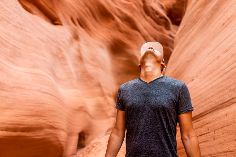Male solo traveler looking up at Antelope slot canyon