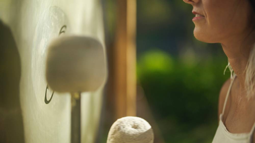 Meditative woman playing gong